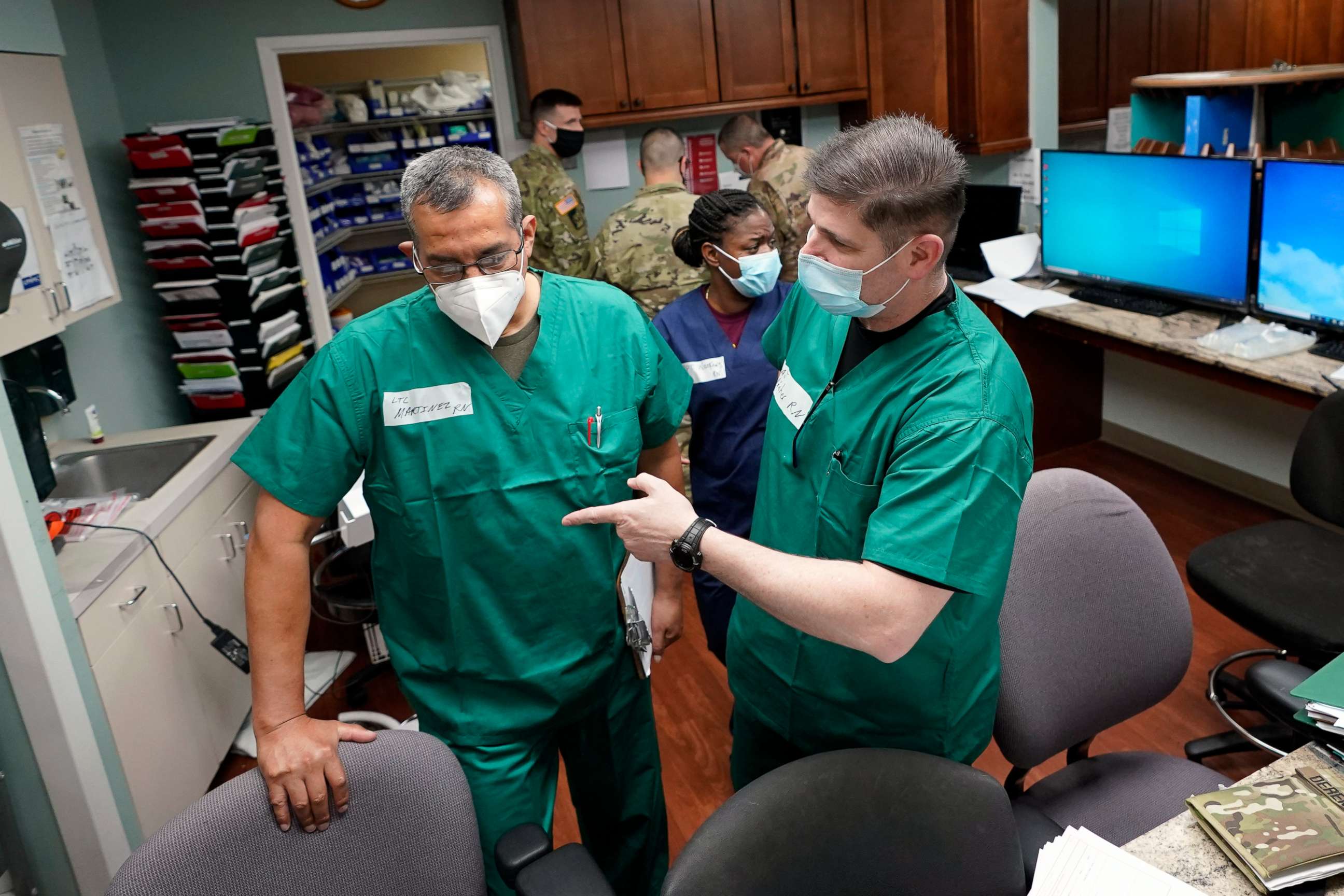PHOTO: In this July 16, 2020 photo, Registered nurses Army Lt. Col. Oswaldo Martinez, left, and Maj. Andrew Wieher, right, with the Urban Augmentation Medical Task Force, work to setup a nurses station in Houston.