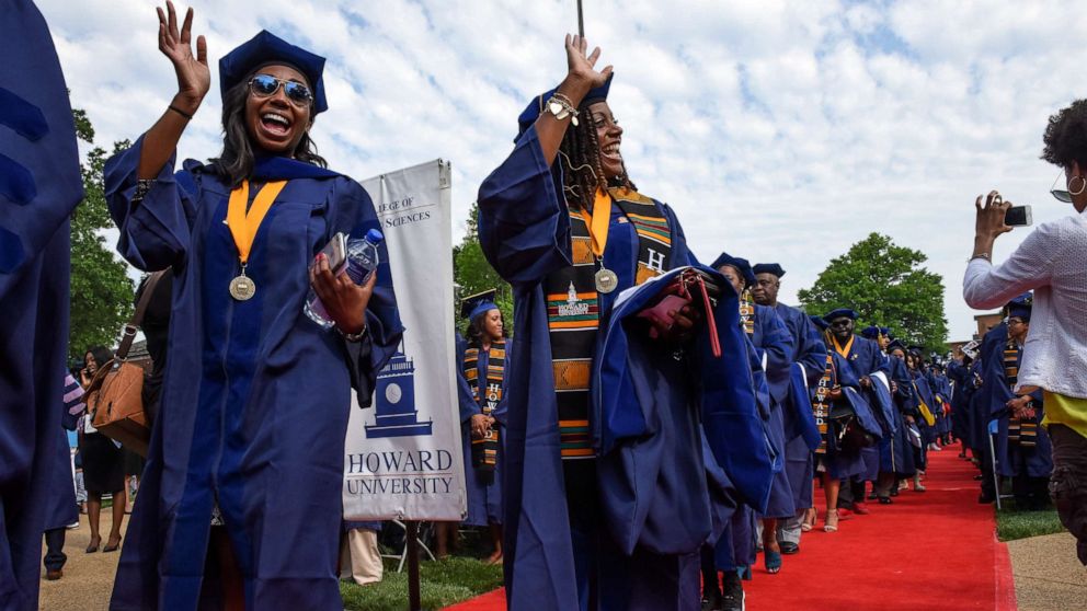 PHOTO: Medical students wave as they walk in Howard University's commencement ceremonies on May, 12, 2018, in Washington.