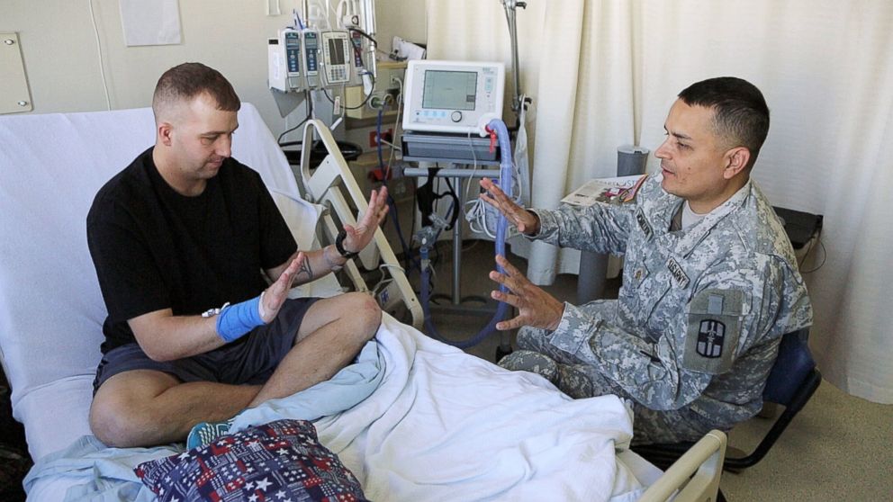 Brian McMillion talks to a recently-wounded soldier at a U.S. medical center in Germany.