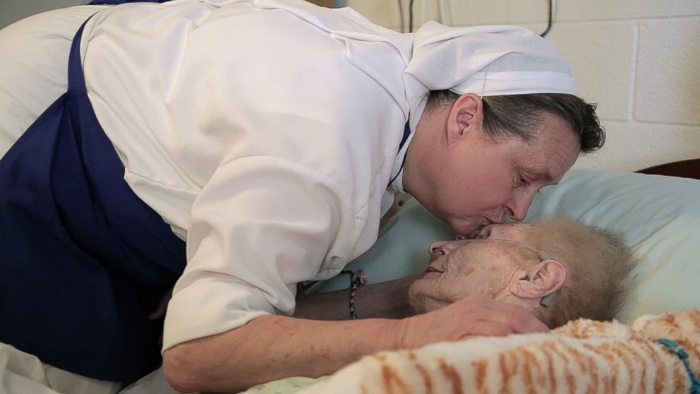 PHOTO: Sister Stephen kisses a dying patient.