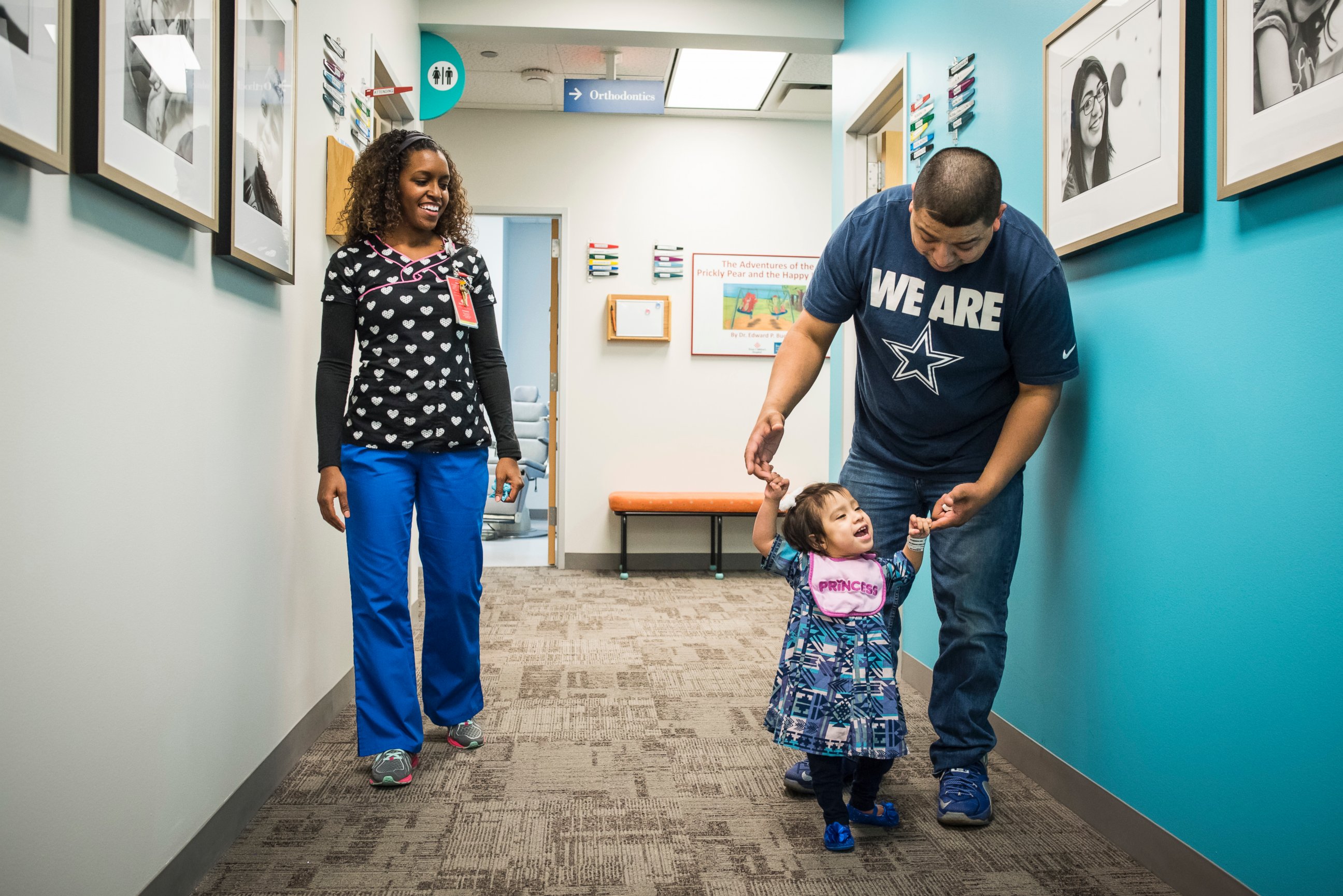 Eric Mata holds daughter Knatalye's hands as she walks down the hall of a clinic at Texas Children's Hospital.