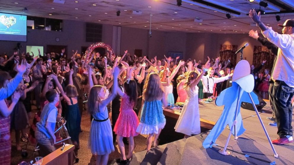 PHOTO: Promgoers put their hands in the air at a free prom just for them.