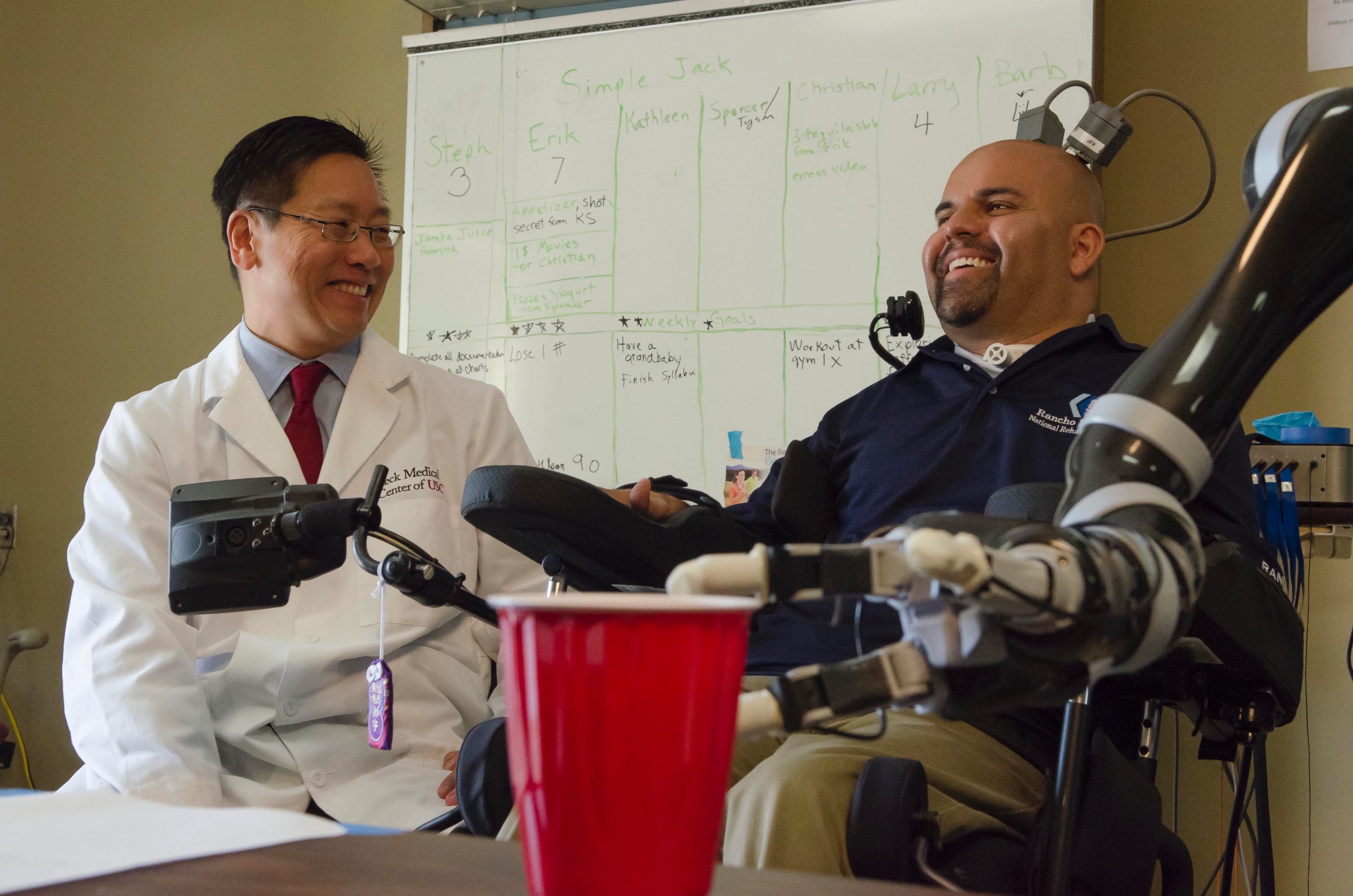 PHOTO: Dr. Charles Y. Liu, professor of neurological surgery, neurology, and biomedical engineering at USC, shares a laugh with patient Erik Sorto. 