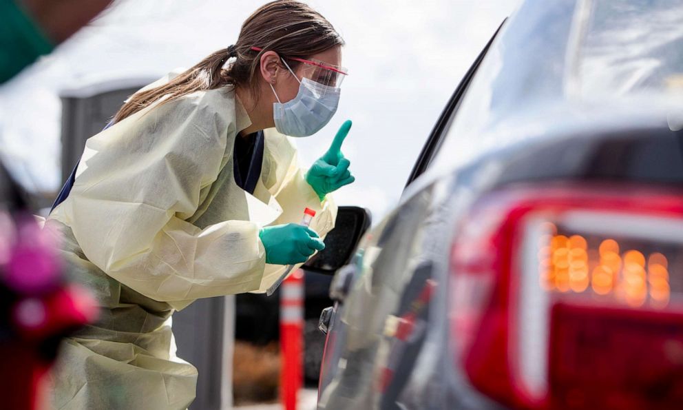 PHOTO: Ashley Layton, an LPN at St. Luke's Meridian Medical Center, communicates with a person exhibiting symptoms before taking swab sample at a special outdoor drive-thru screening station for coronavirus COVID-19 Tuesday, March 17, 2020.