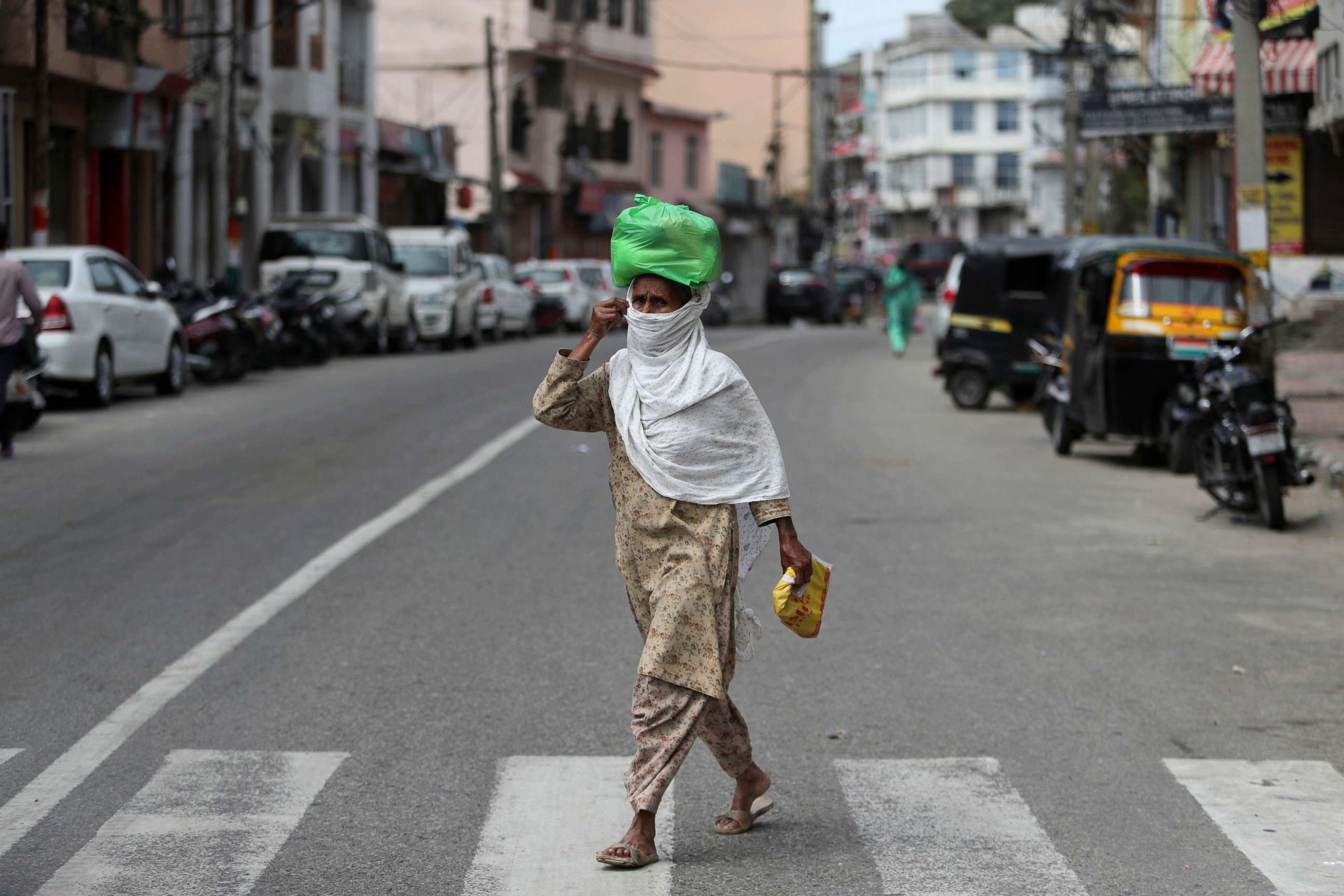 PHOTO: An Indian woman wearing a mask walks through a closed market during lockdown to prevent the spread of new coronavirus in Jammu, India, March 31, 2020. 