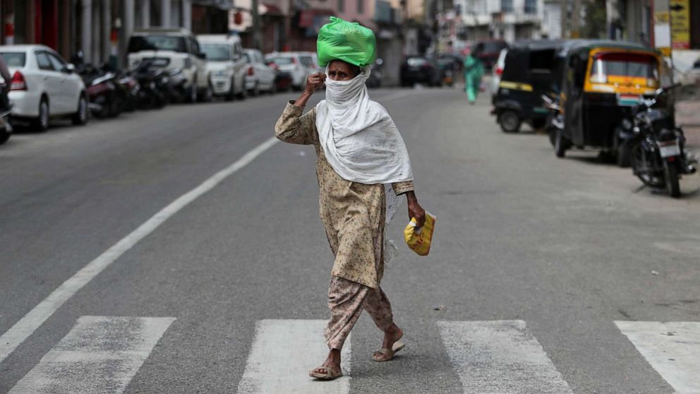 PHOTO: An Indian woman wearing a mask walks through a closed market during lockdown to prevent the spread of new coronavirus in Jammu, India, March 31, 2020. 