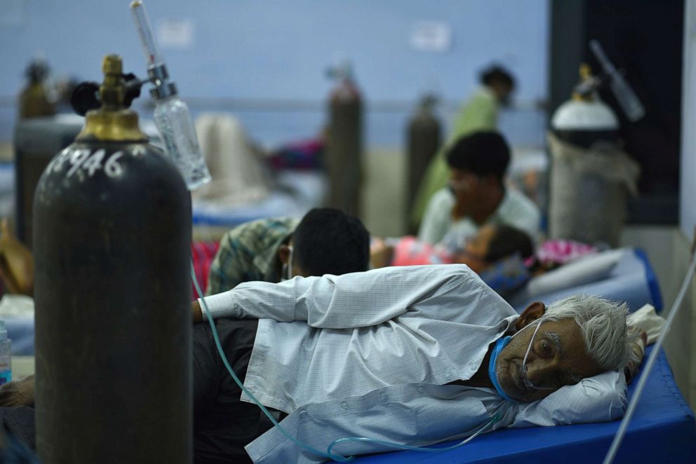 PHOTO: A suspected COVID-19 patient receives oxygen supply at a makeshift hospital on the outskirts of New Delhi, May 24, 2021. 