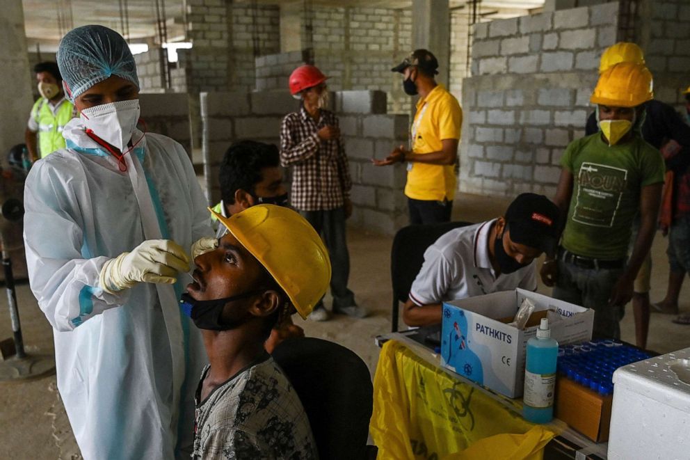 PHOTO: A health worker takes a swab sample from a laborer at a construction site in New Delhi, India, on June 10, 2021.