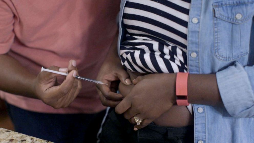 PHOTO: James helps his wife, LaTanya, with and injection during the IVF process.