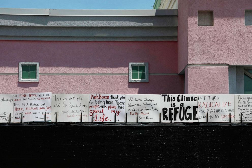 PHOTO: Signs by abortion rights activists sit on a fence outside of the Jackson Women's Health Organization in Jackson, Miss., July 7, 2022. The clinic performed it's last abortion July 7.