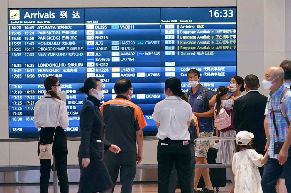 PHOTO: People wearing face masks are seen at an arrival lobby of Haneda airport in Tokyo on Aug. 23, 2022, amid the coronavirus pandemic.