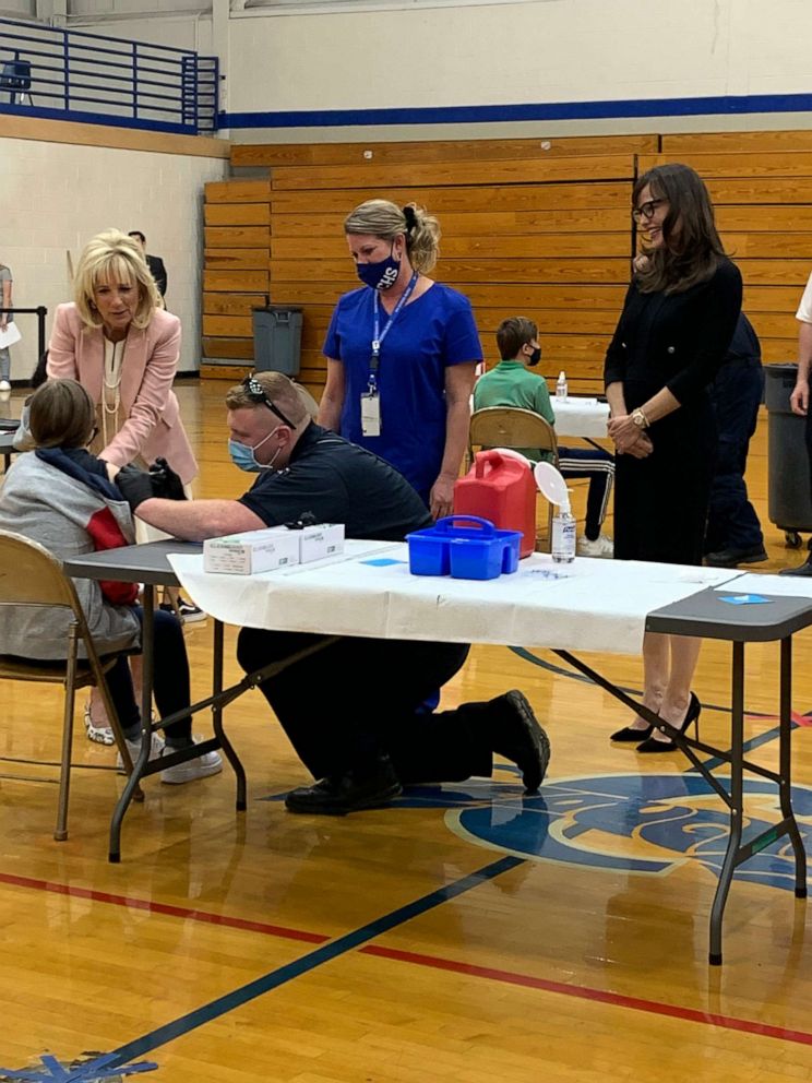 PHOTO: First lady Dr. Jill Biden holds the hand of a teenager getting vaccinated, left, as actress Jennifer Garner, right, looks on at Capital High School in Charleston, W.V., on May 13, 2021.