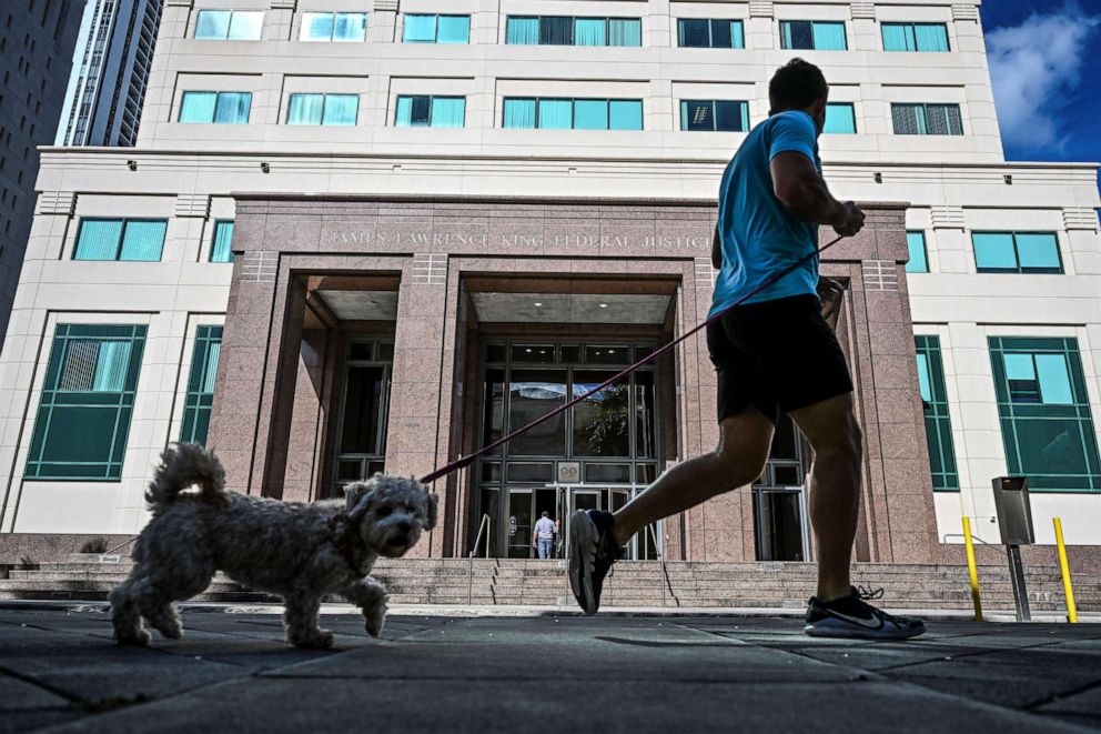 PHOTO: A man jogs with his dog outside the James Lawrence King Federal Justice Building on January 17, 2023 in Miami.