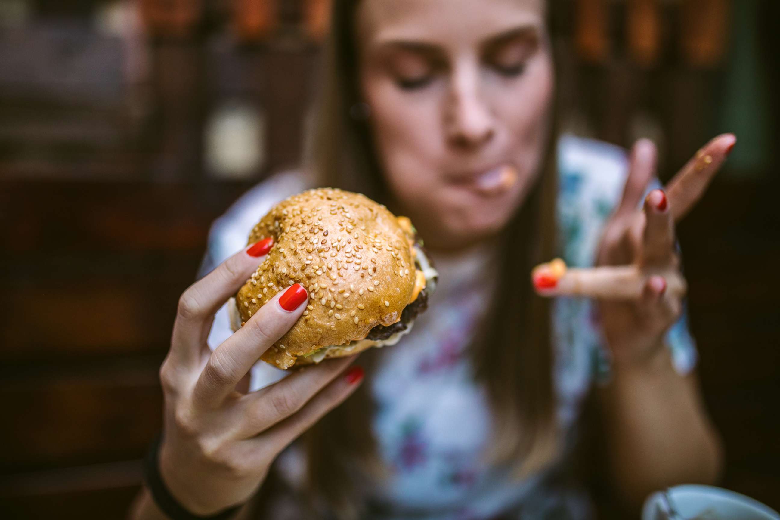 PHOTO: A young girl eats a cheeseburger in this stock photo.