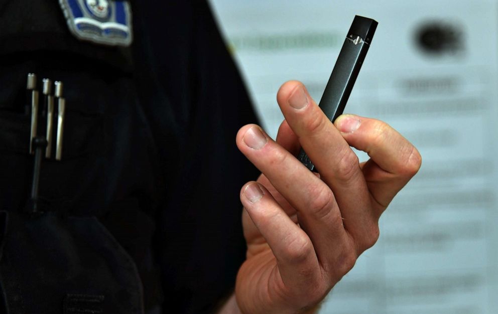 PHOTO: A JUUL device is held by a detective with the local police department school resource unit, May 3, 2018, at a town hall meeting in Arlington, Va.