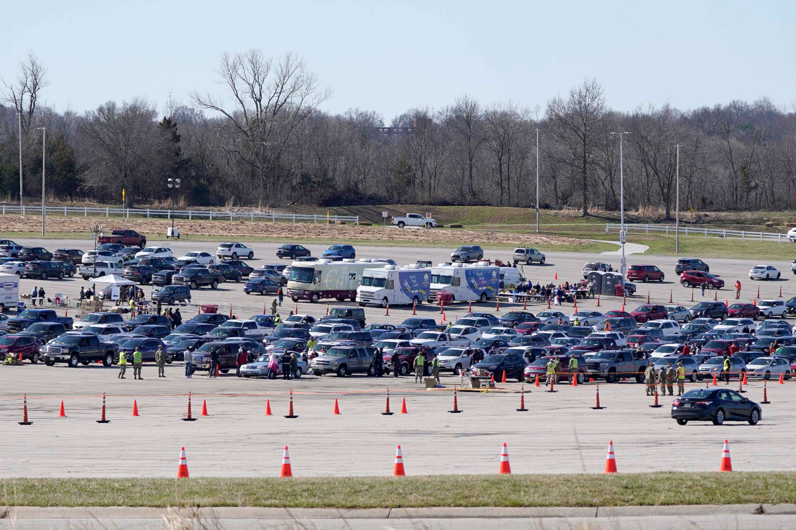 PHOTO: Patients in vehicles line up for COVID-19 vaccination shots in a sports complex parking lot in Kansas City, Mo., March 19, 2021. 