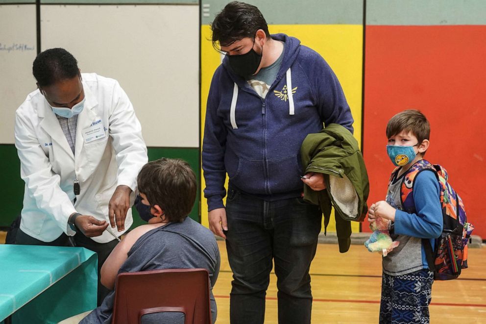PHOTO: Ahmed Ali of Othello Station Pharmacy gives the first dose of the Pfizer-BioNTech COVID-19 vaccine to Loic Schlagel, 9, during a Seattle Public Schools' school-day clinic at Bailey Gatzert Elementary in Seattle, Nov. 8, 2021