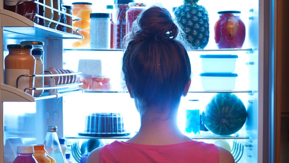 PHOTO: A woman is pictured standing in front of the open refrigerator late at night in this undated stock photo.