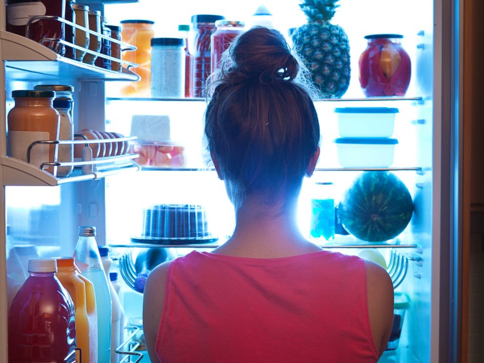 PHOTO: A woman is pictured standing in front of the open refrigerator late at night in this undated stock photo.