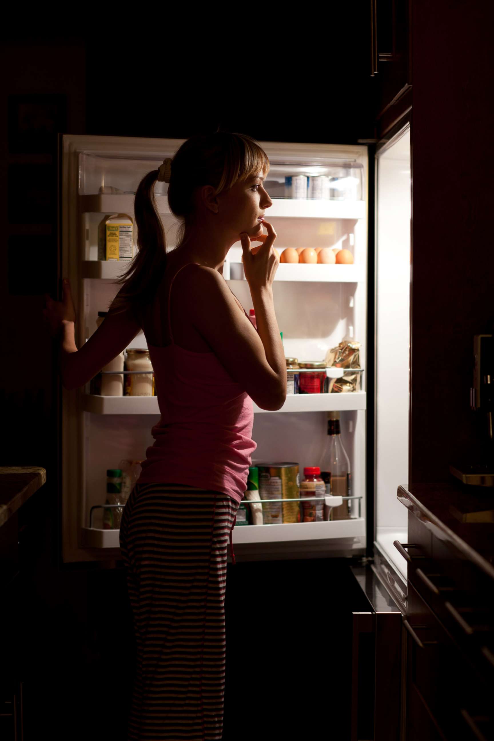 PHOTO: A woman is seen looking at food at night in this undated stock photo.