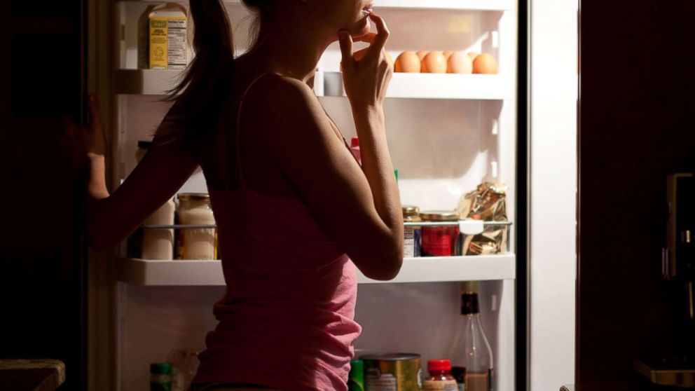 PHOTO: A woman is seen looking at food at night in this undated stock photo.
