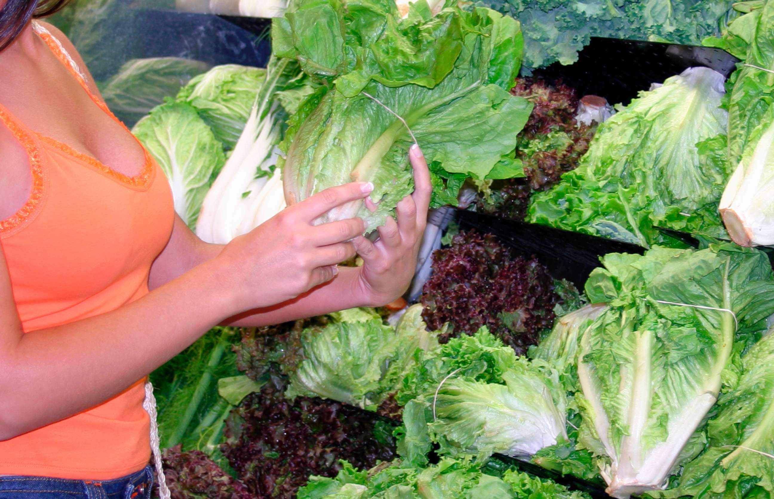 PHOTO: A woman is pictured holding romaine lettuce at a store.