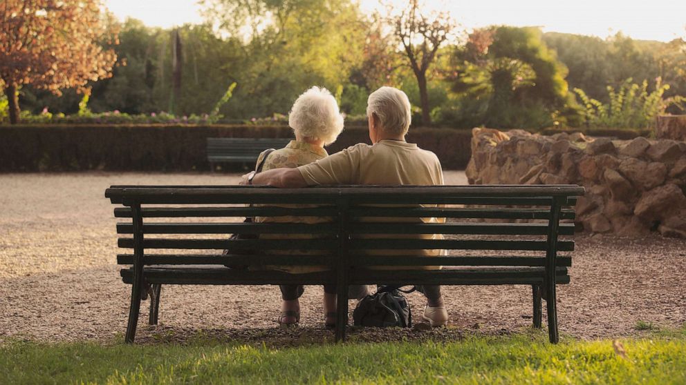 PHOTO: Senior couple sitting on bench in park