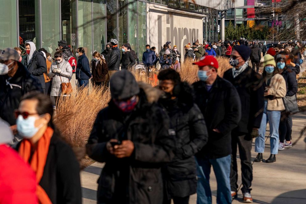 PHOTO: People wait for at-home Covid-19 test kits in a long line that snakes multiple times around the Shaw Library in Washington, D.C., Dec. 22, 2021.