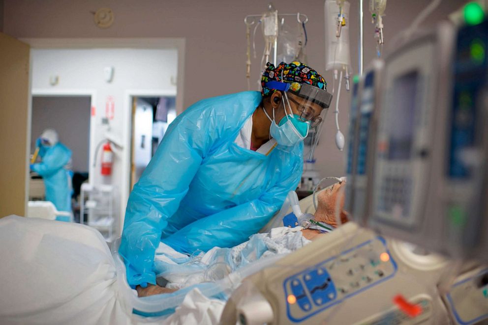 PHOTO: FILE - Healthcare worker Demetra Ransom comforts a patient in the Covid-19 ward at United Memorial Medical Center in Houston, Dec. 4, 2020.