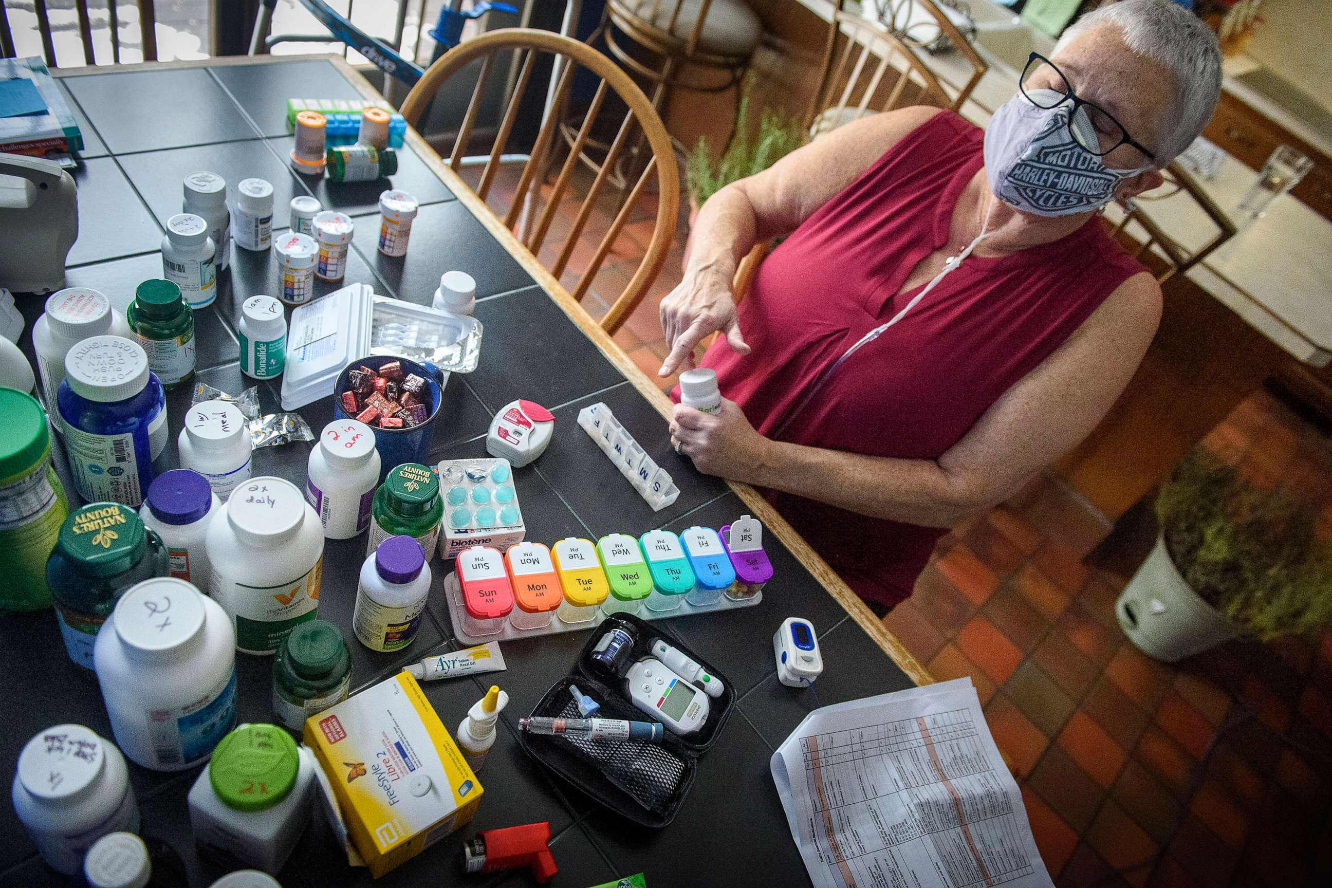 PHOTO: At her kitchen table on Jan. 14, 2022, in Kensington, Connecticut, Kathy Spencer sorts the dozens of pills she must take since contracting COVID in November 2020.