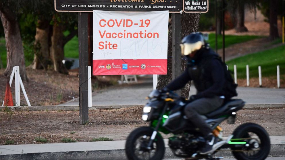 PHOTO: A motorcyclist rides past a Covid-19 vaccine site in Los Angeles, July 6, 2021.