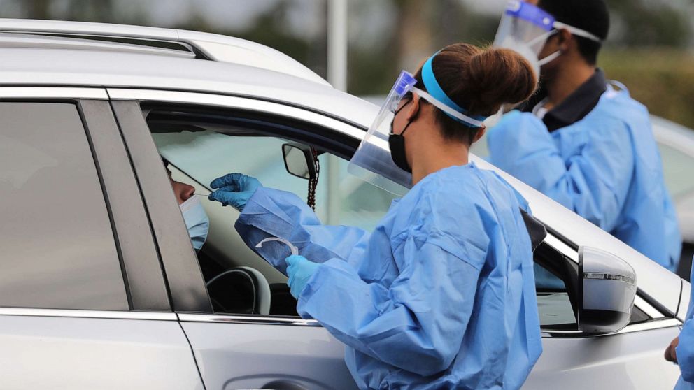 PHOTO: A medical worker collects a swab sample at a COVID-19 drive-through testing site in Los Angeles, Jan. 10, 2022. 