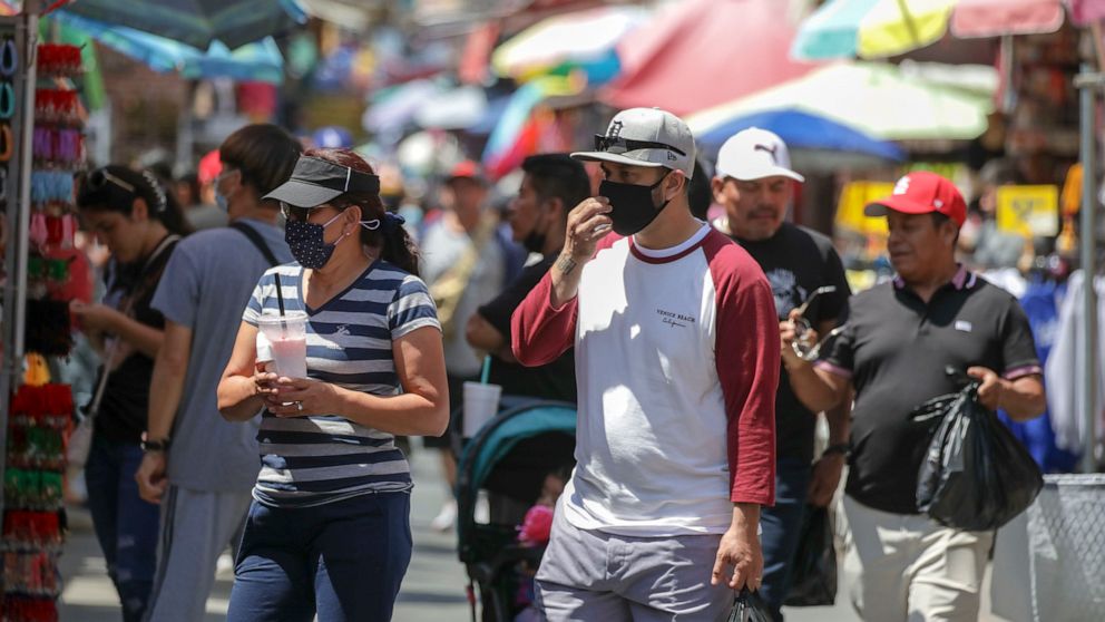 PHOTO: People shop in mask and without masks in a very congested market Santee Alley on July 14, 2022, in Los Angeles.
