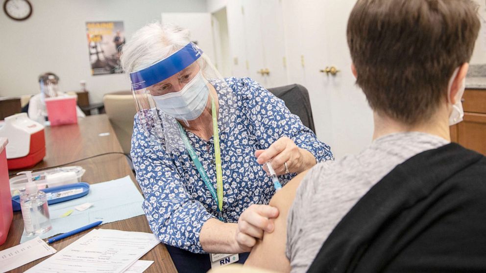 PHOTO: Registered nurse Holly Burnham vaccinates Lynn Pelletier, who works as a nurse at Portland Public Schools, at the Northern Light Homecare and Hospice COVID-19 vaccine clinic in South Portland, ME., Jan 13, 2021.