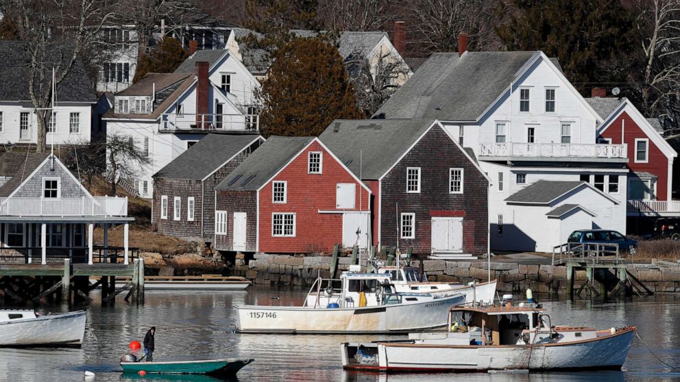 PHOTO: A boater motors past lobster boats moored off North Haven, Maine, Monday, March 16, 2020. 