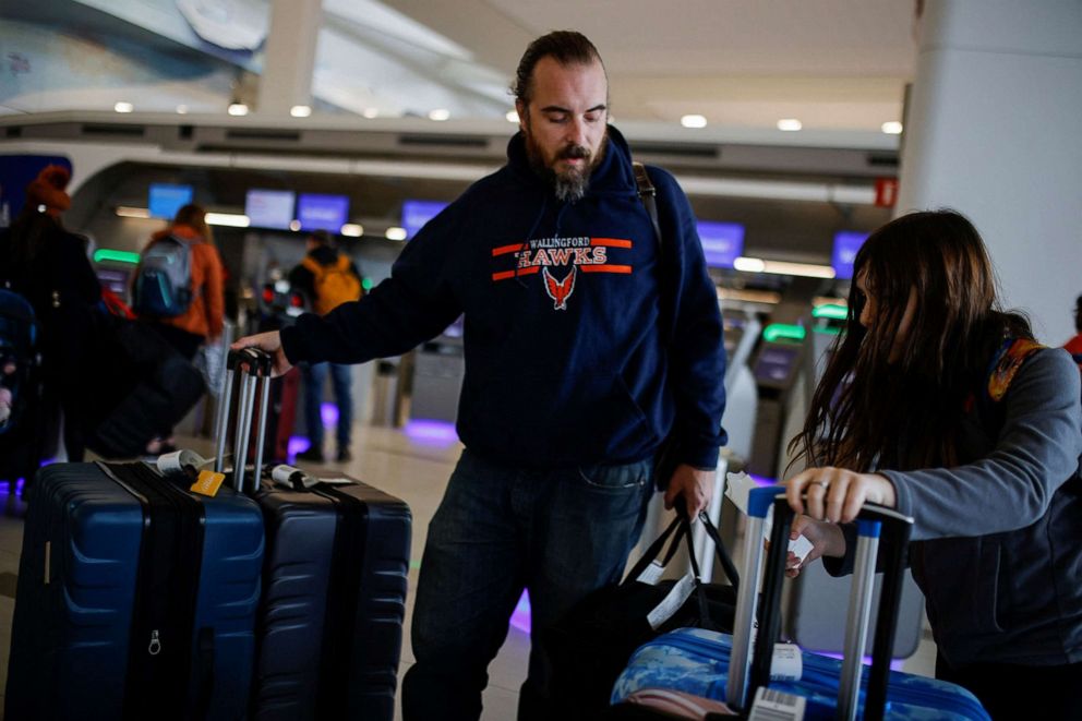 PHOTO: People without masks arrive to at La Guardia Airport after the Biden administration announced it would no longer enforce a COVID-19 mask mandate on public transportation, in New York, U.S., April 19, 2022.