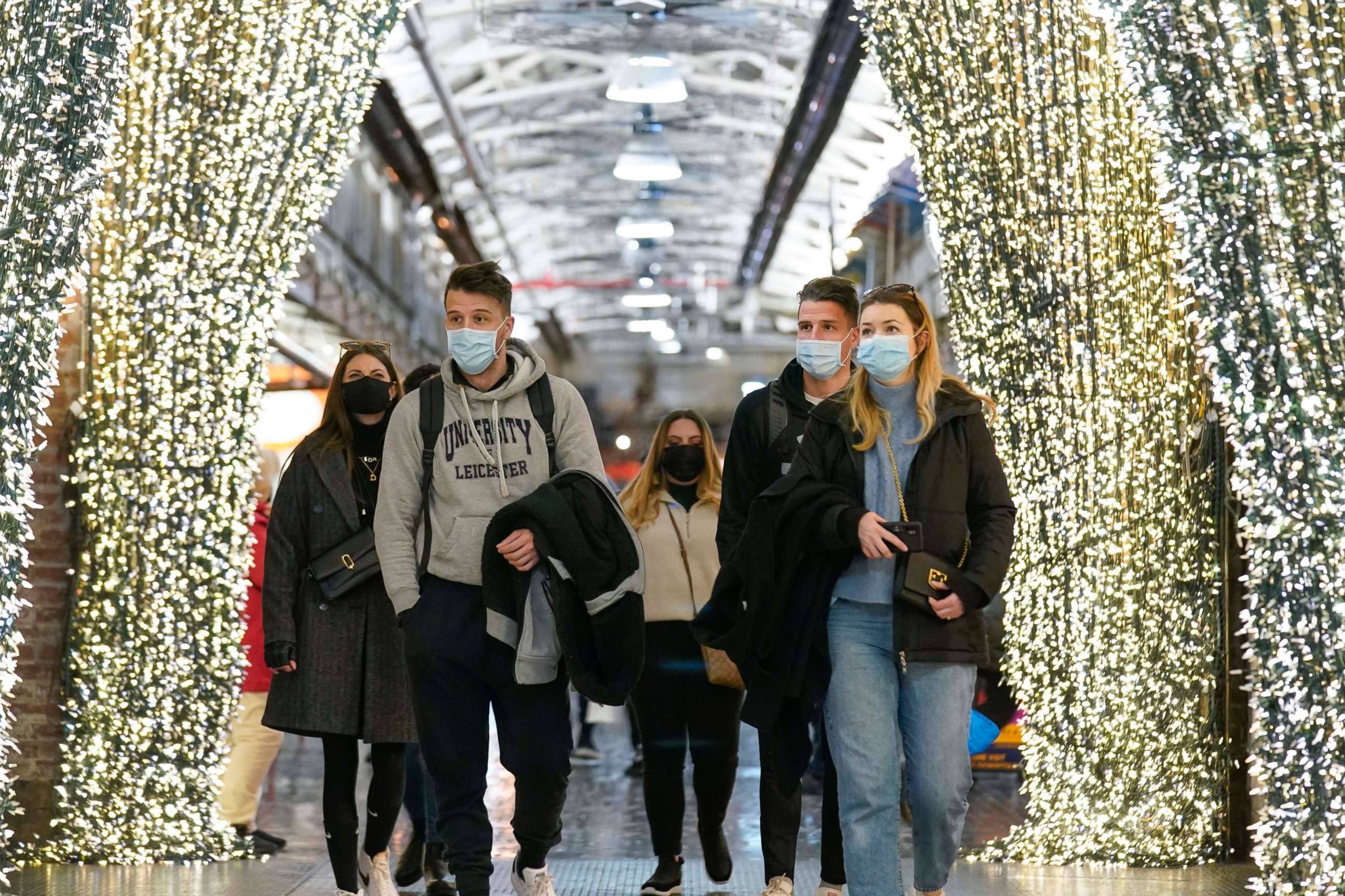 PHOTO: People wear masks while walking through an indoor shopping area in New York, Feb. 9, 2022.