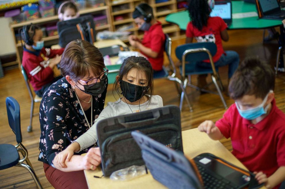 PHOTO: Kindergarten teacher Karen Drolet, left, works with a student at Raices Dual Language Academy, a public school in Central Falls, R.I., Feb. 9, 2022.