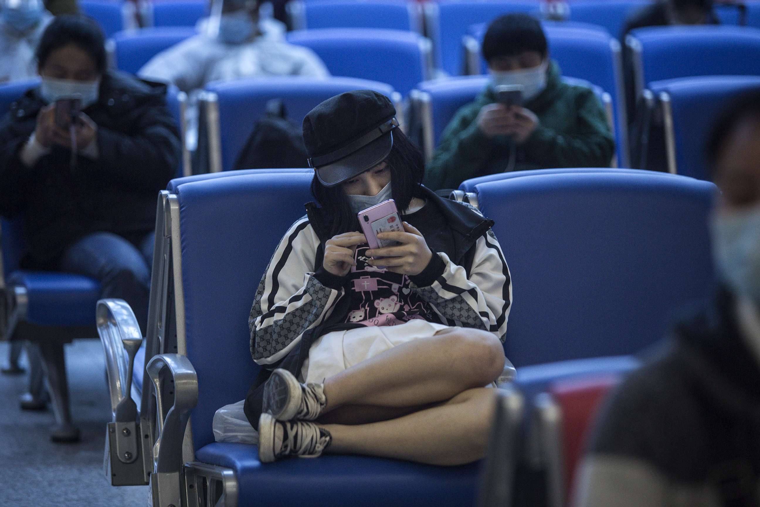 PHOTO: A passenger uses an iPhone while sitting in a waiting room at a railway station on April 7,2020.