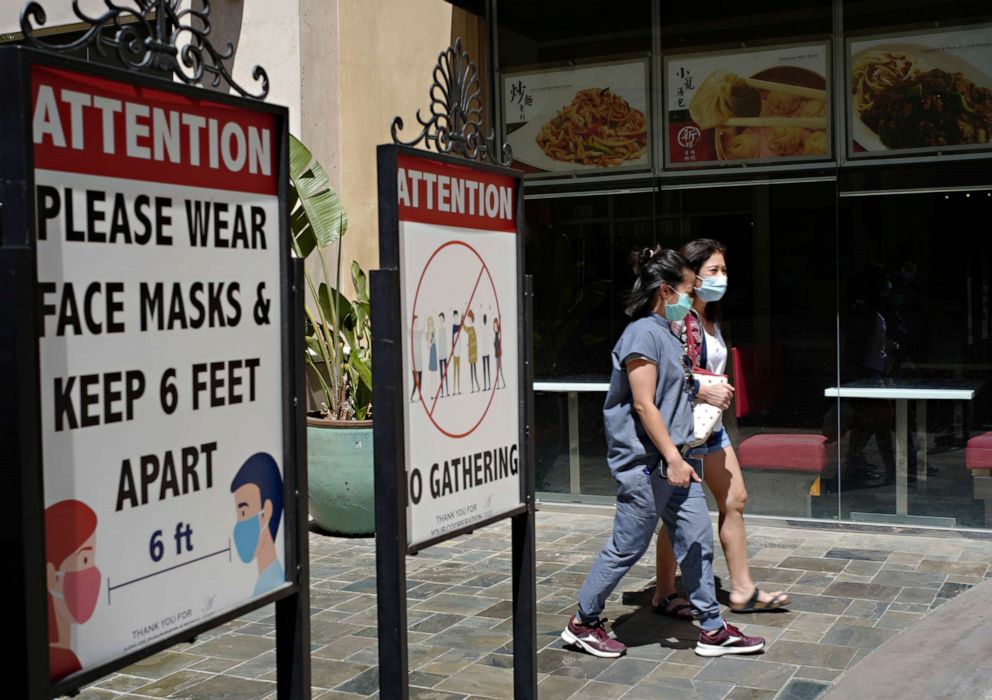 PHOTO: Les clients portent des masques faciaux dans un centre commercial extérieur avec une entreprise fermée au milieu de la pandémie de COVID-19 à Los Angeles, le 11 juin 2021.