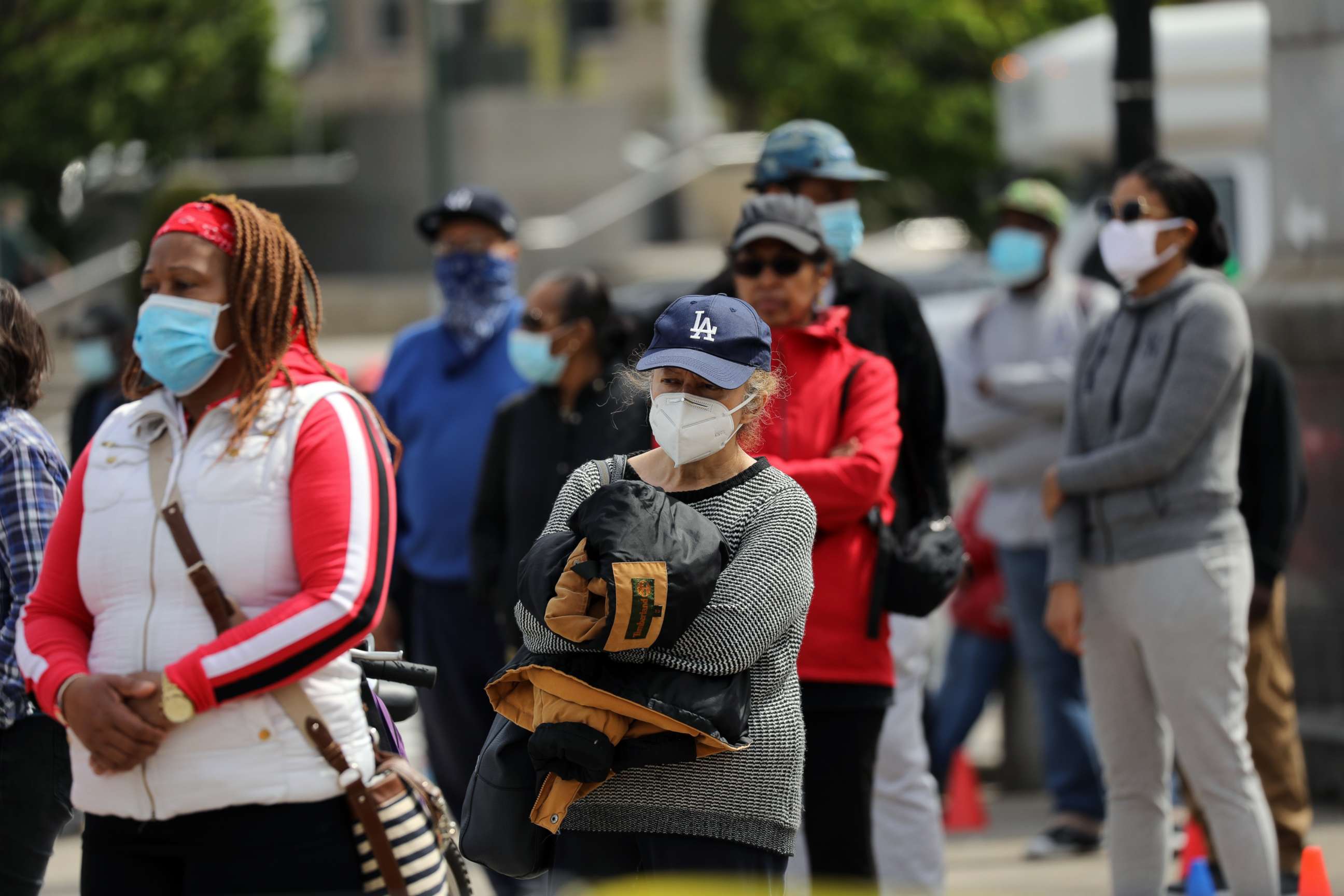 PHOTO: People receive protective masks and bandannas as they are handed out in Prospect Park as face coverings become mandatory in many establishments on May 3, 2020 in New York.