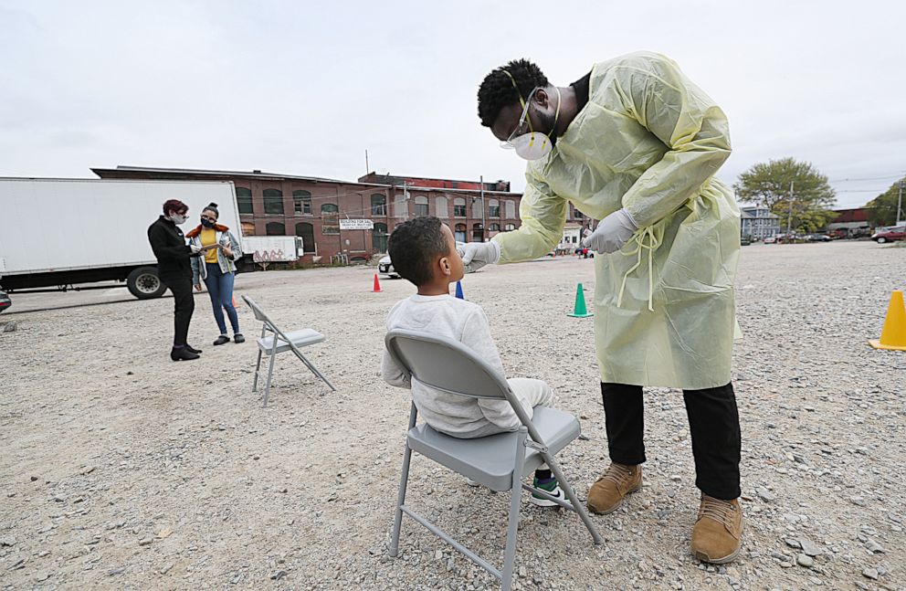 PHOTO: A nurse gives a  COVID-19 test to seven year old Hector Mena at a testing site in a parking lot off Manchester Street in Lawrence, Mass., Oct. 20, 2020.