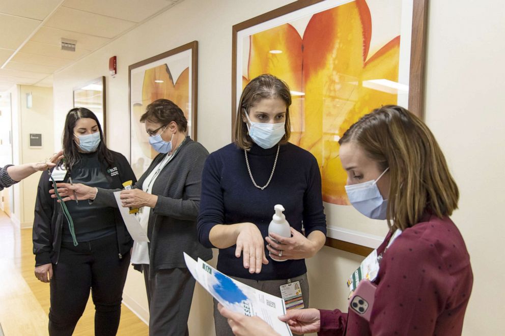 PHOTO: Eve Poczatek, second from right, director of the Center for Clinical Wellness, distributes flyers with information about employee access to mental health support at Rush University Medical Center in Chicago, Jan. 19, 2022.
