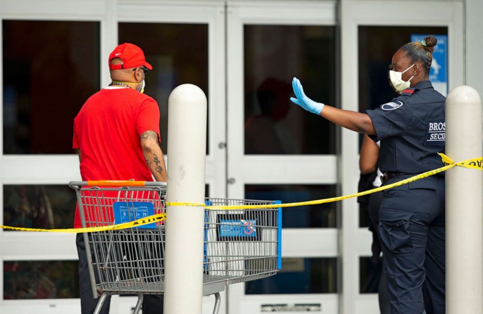PHOTO: A security guard directs customers to enter the Walmart Supercenter as the coronavirus pandemic continues on Sunday, April 5, 2020, in Miami.