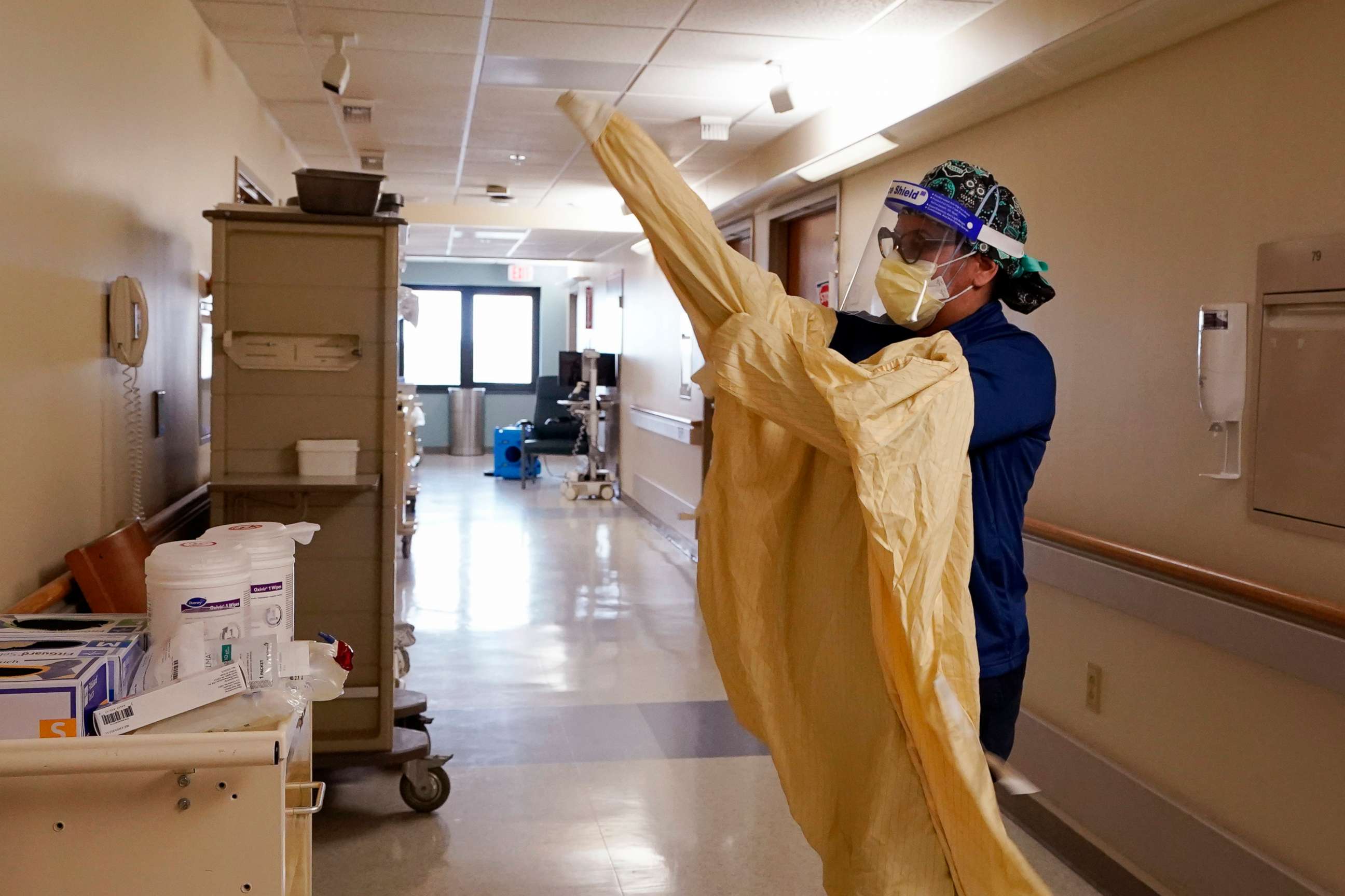 PHOTO: Registered Nurse Monica Quintana dons protective gear before entering a room at the William Beaumont hospital, April 21, 2021, in Royal Oak, Mich.