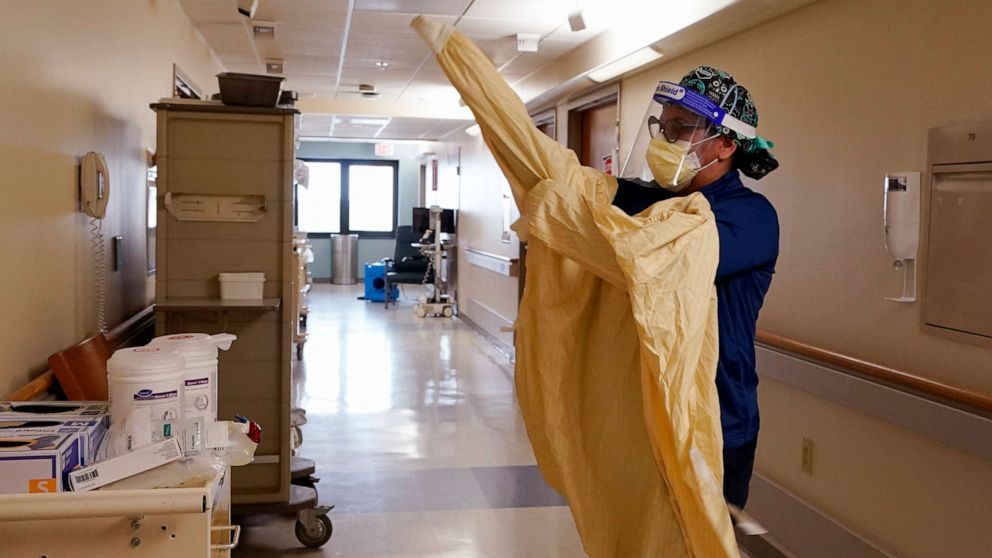 PHOTO: Registered Nurse Monica Quintana dons protective gear before entering a room at the William Beaumont hospital, April 21, 2021, in Royal Oak, Mich.