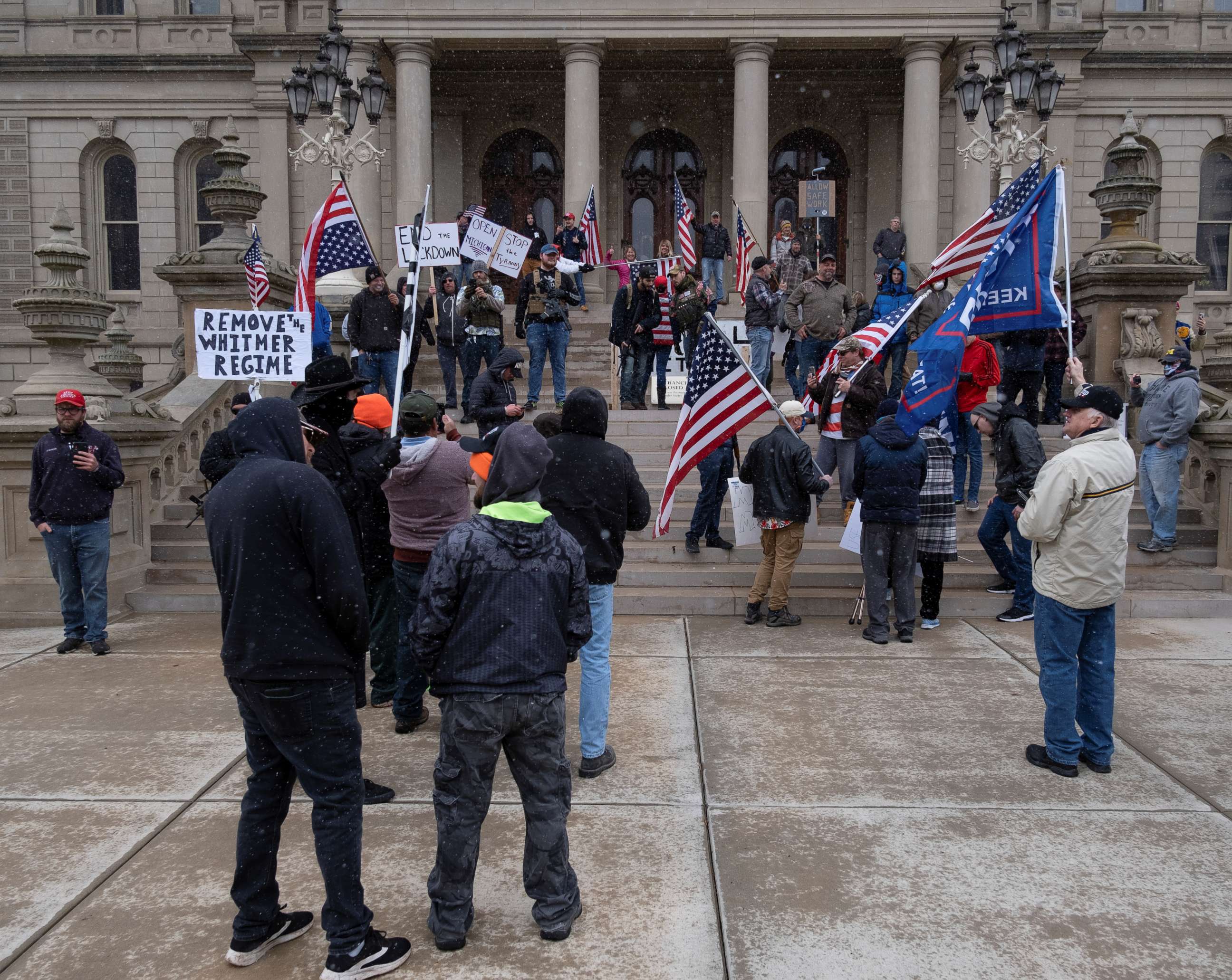PHOTO: People hold flags and placards as hundreds of supporters of the Michigan Conservative Coalition protest against the state's extended stay-at-home order, April 15, 2020.