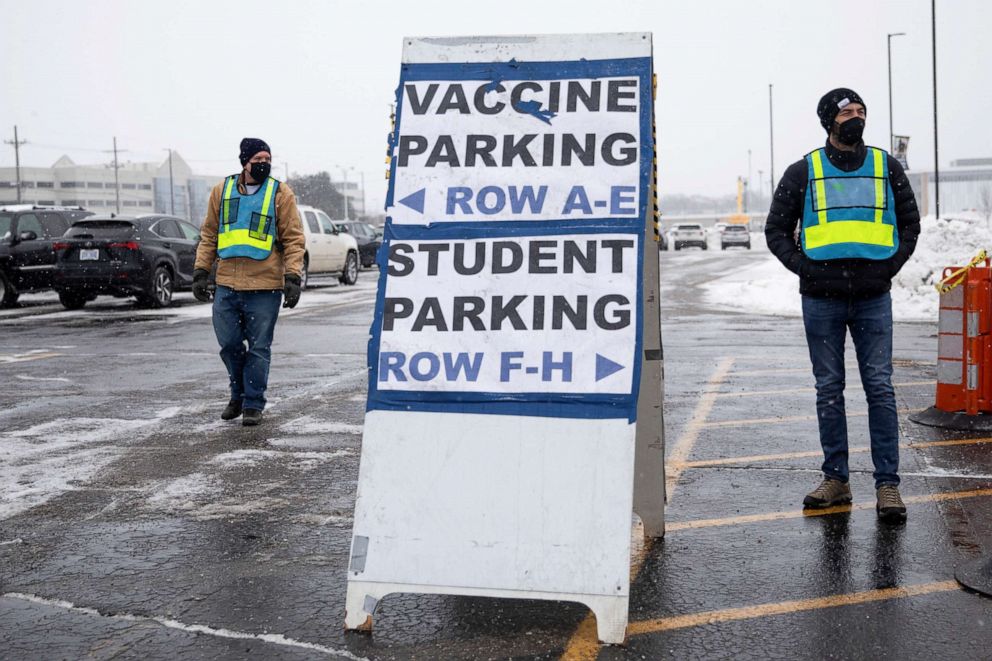PHOTO: Parking lot attendants direct parking as people arrive for the coronavirus disease vaccines at a mass vaccination site at the Schoolcraft College, in Livonia, Mich., Feb. 5, 2021.
