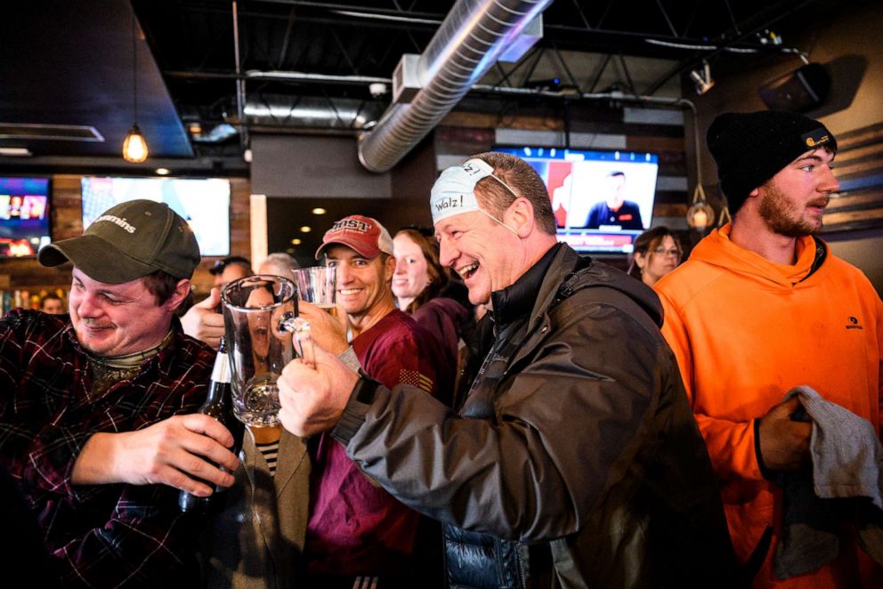 PHOTO: In this Dec. 16, 2020, file photo, a man lifts his drink with friends at the bar at Alibi Drinkery in Lakeville, Minn.