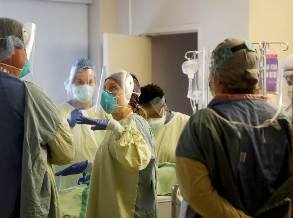 PHOTO: A registered nurse confers with a fellow healthcare worker after they rotated a COVID-19 patient in the third-floor ICU at Bethesda Hospital on May 7, 2020, in St. Paul, Minn.